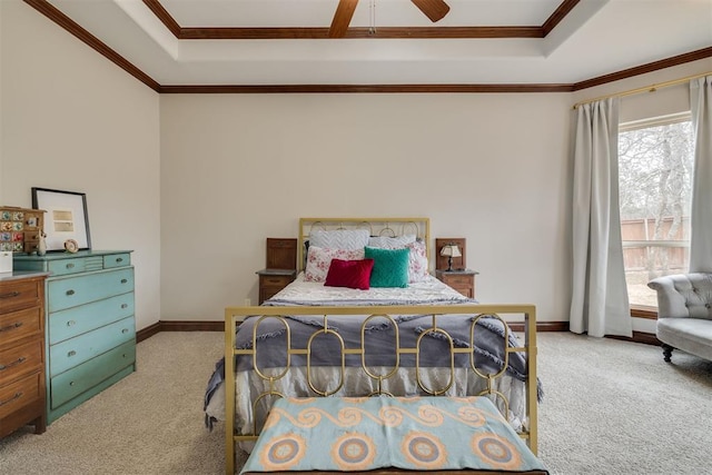 bedroom featuring baseboards, light colored carpet, ornamental molding, a raised ceiling, and a ceiling fan