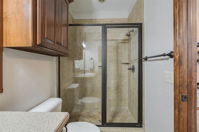 bathroom featuring a stall shower, toilet, and vanity