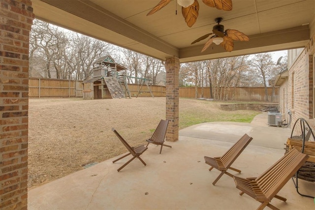 view of patio featuring ceiling fan, cooling unit, a playground, and a fenced backyard