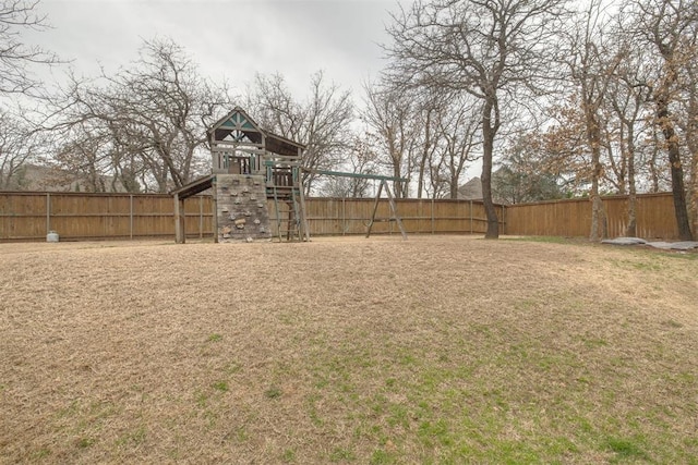 view of yard with a fenced backyard and a playground