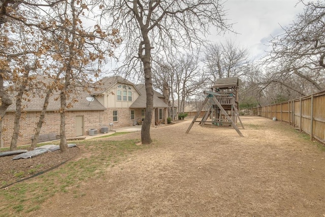 view of yard with a patio area, central AC unit, a playground, and fence