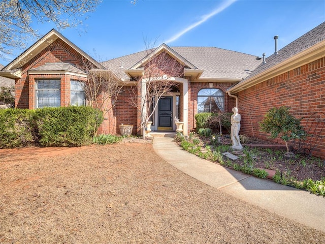 ranch-style home with brick siding and roof with shingles