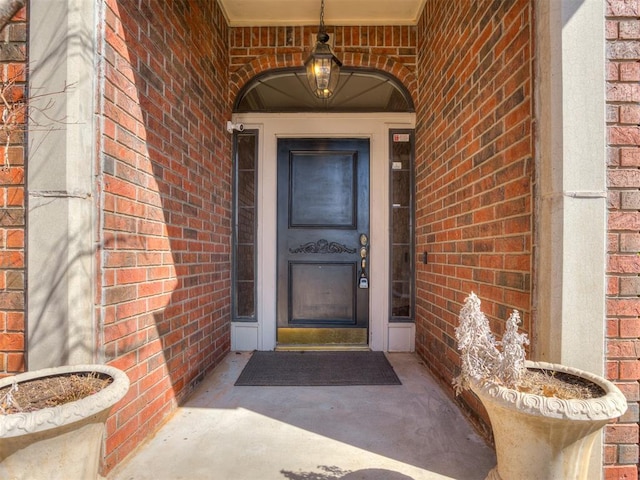 view of exterior entry featuring brick siding