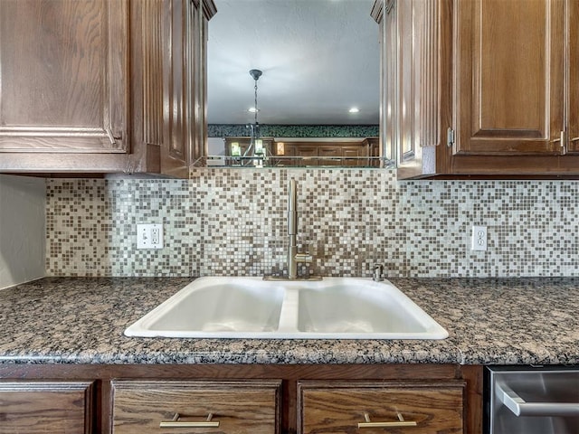 room details with tasteful backsplash, dishwasher, and a sink