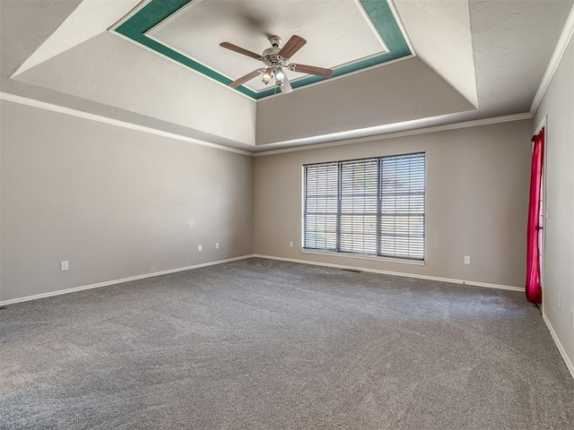 unfurnished room featuring ceiling fan, baseboards, a tray ceiling, ornamental molding, and carpet flooring