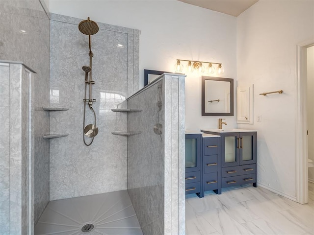 full bath featuring vanity, a walk in shower, marble finish floor, and baseboards