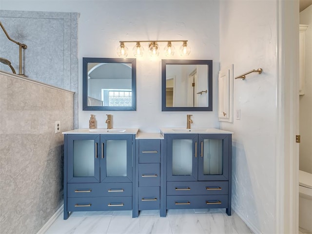 bathroom featuring toilet, marble finish floor, and vanity