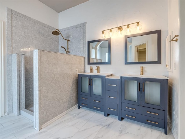 bathroom featuring double vanity, marble finish floor, walk in shower, and a sink