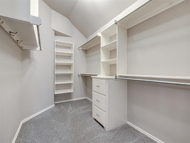 walk in closet with carpet floors and vaulted ceiling