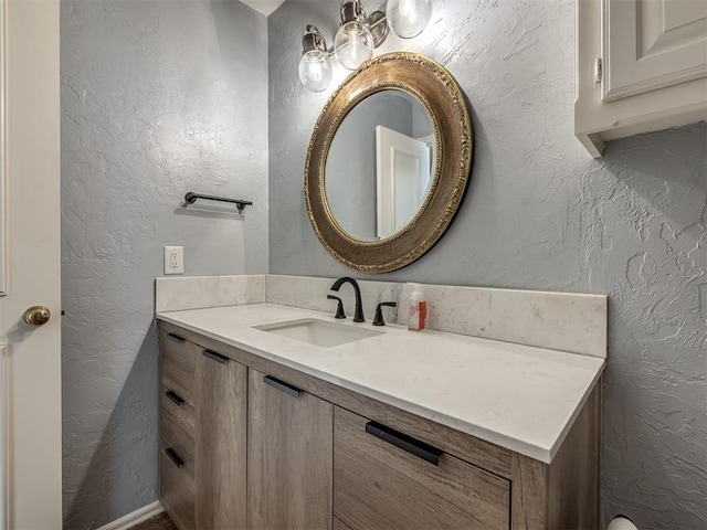 bathroom with vanity and a textured wall