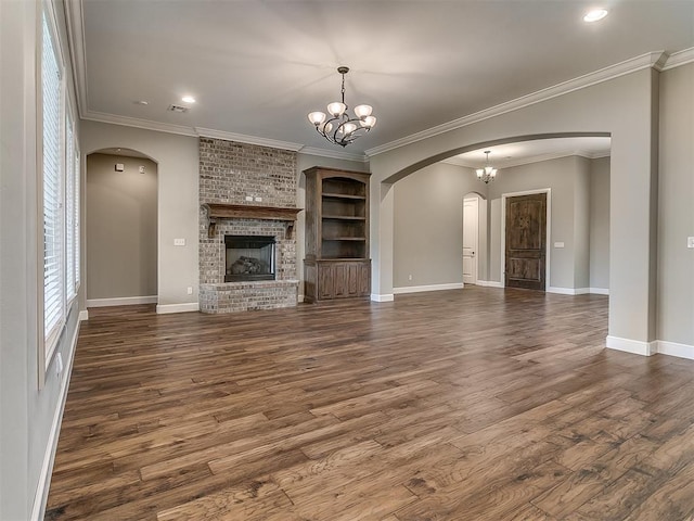 unfurnished living room with arched walkways, dark wood-style floors, and a chandelier