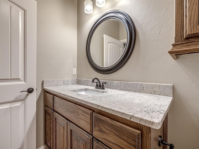 bathroom featuring vanity and a textured wall