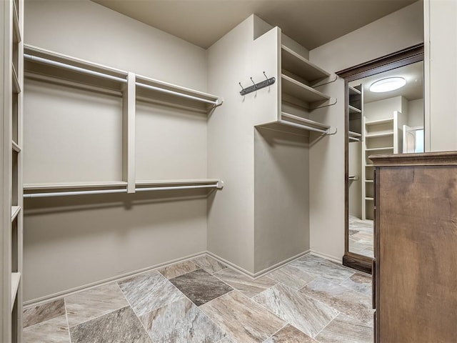 walk in closet with stone finish floor