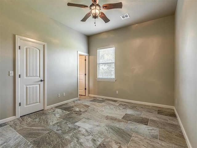 empty room with visible vents, baseboards, and ceiling fan