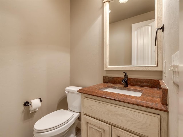 half bath featuring toilet and vanity