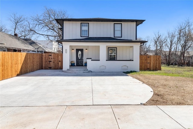 view of front of home with covered porch, board and batten siding, and fence