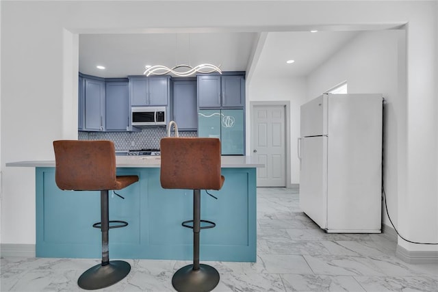 1612 N Klein Ave, Oklahoma City, OK 73106 - kitchen with white appliances, light countertops, a kitchen breakfast bar, marble finish floor, and backsplash