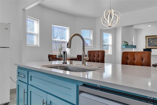 1612 N Klein Ave, Oklahoma City, OK 73106 - kitchen featuring blue cabinetry, freestanding refrigerator, a sink, light countertops, and dishwasher