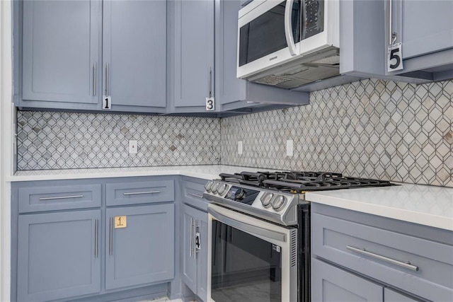 1612 N Klein Ave, Oklahoma City, OK 73106 - kitchen with stainless steel gas stove, gray cabinets, backsplash, light countertops, and white microwave
