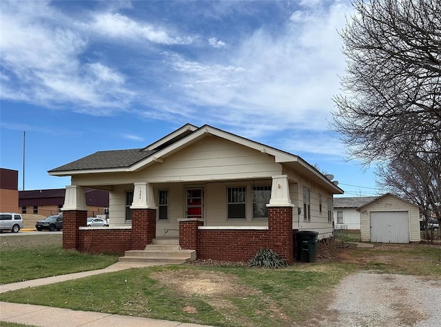 view of front facade with an outbuilding, a porch, a garage, dirt driveway, and brick siding