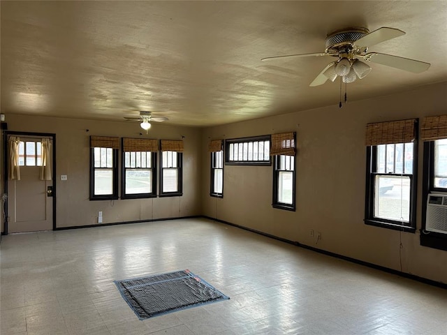 empty room featuring plenty of natural light, baseboards, and a ceiling fan