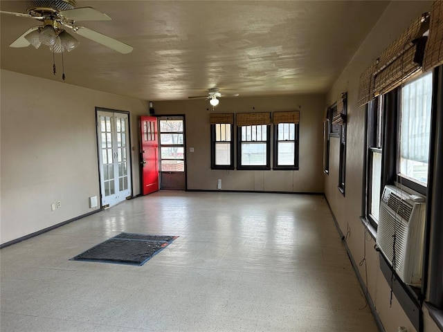 interior space with light floors, baseboards, and ceiling fan