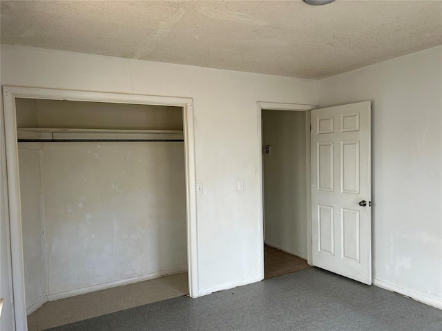 unfurnished bedroom with a closet, a textured ceiling, and baseboards