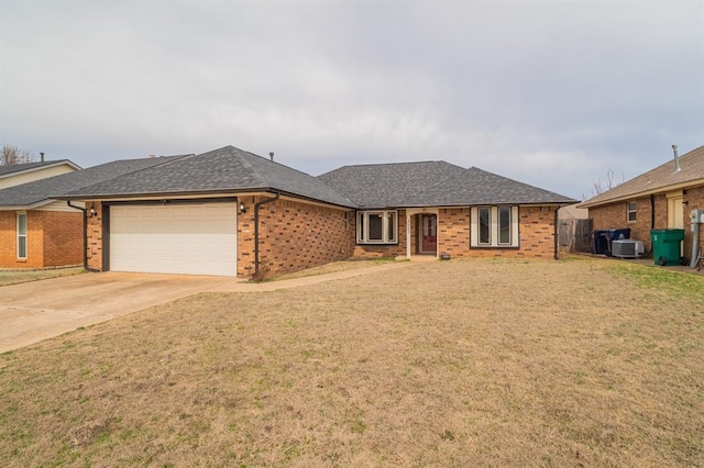 ranch-style home with a front yard, an attached garage, a shingled roof, concrete driveway, and brick siding