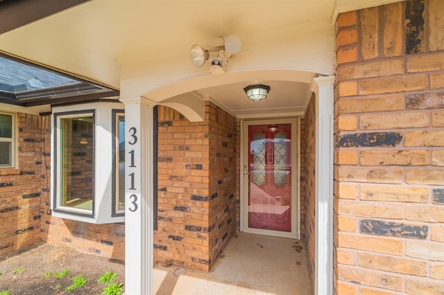 property entrance featuring brick siding