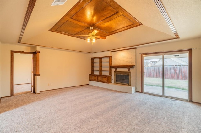 unfurnished living room featuring a ceiling fan, visible vents, a tray ceiling, a fireplace, and light carpet