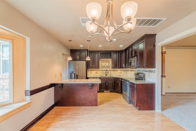 kitchen with visible vents, dark brown cabinets, appliances with stainless steel finishes, and a sink