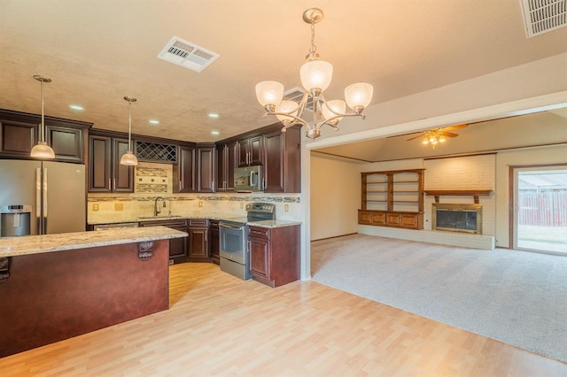 kitchen with light stone counters, visible vents, appliances with stainless steel finishes, and a sink