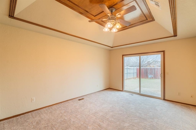 spare room with visible vents, baseboards, carpet, a raised ceiling, and a ceiling fan