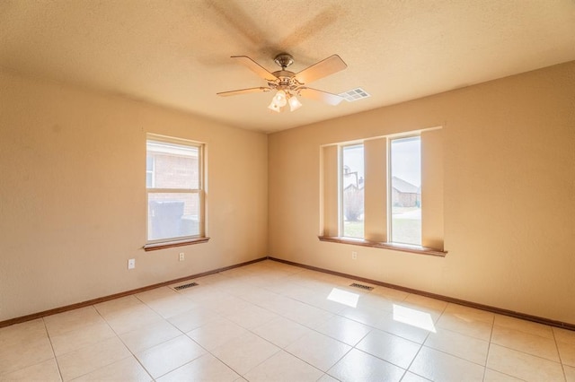 empty room with visible vents, baseboards, and ceiling fan