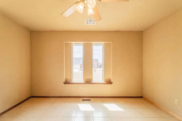 empty room with a ceiling fan, visible vents, and baseboards