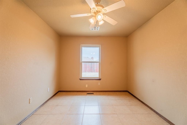 unfurnished room featuring visible vents, baseboards, light tile patterned flooring, and a ceiling fan