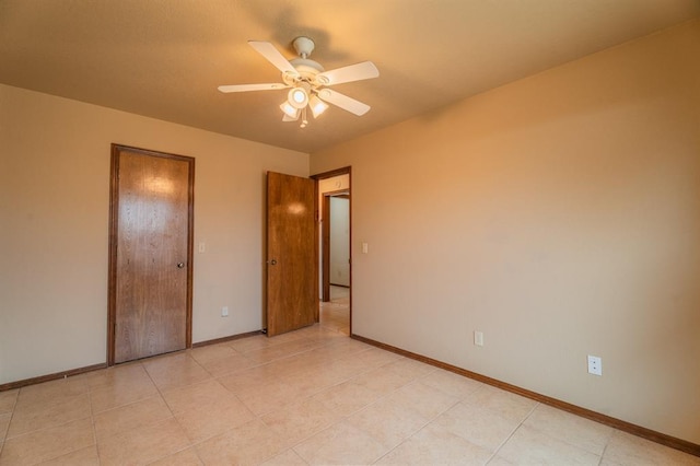 unfurnished bedroom featuring baseboards, light tile patterned flooring, and a ceiling fan