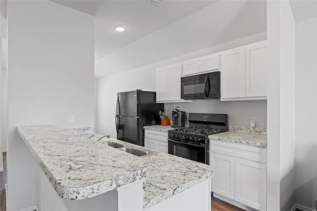 kitchen with black appliances, light countertops, a peninsula, white cabinetry, and a sink