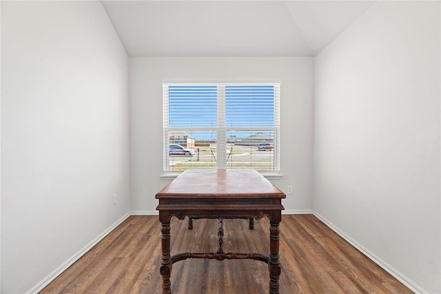 office space featuring vaulted ceiling, wood finished floors, and baseboards