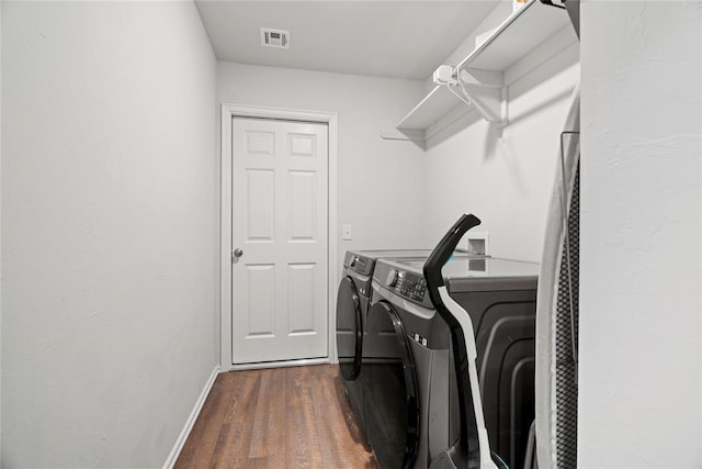 clothes washing area with visible vents, independent washer and dryer, dark wood-style floors, baseboards, and laundry area