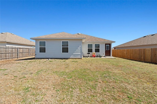 back of property featuring a lawn and a fenced backyard