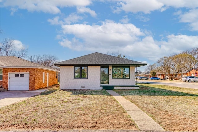 view of front facade featuring a front yard, driveway, an attached garage, crawl space, and brick siding