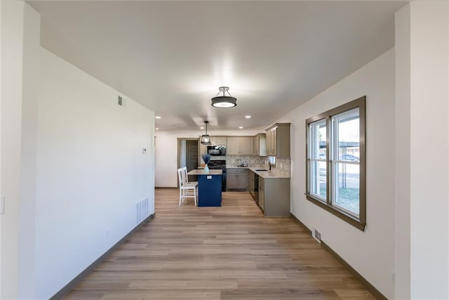 kitchen featuring visible vents, a sink, decorative backsplash, black appliances, and gray cabinetry