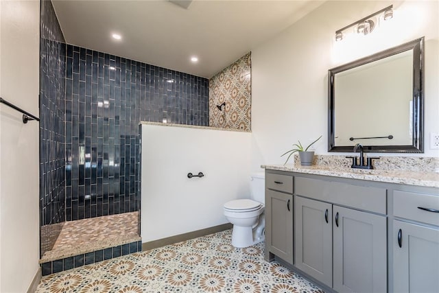 bathroom featuring toilet, a walk in shower, recessed lighting, baseboards, and vanity