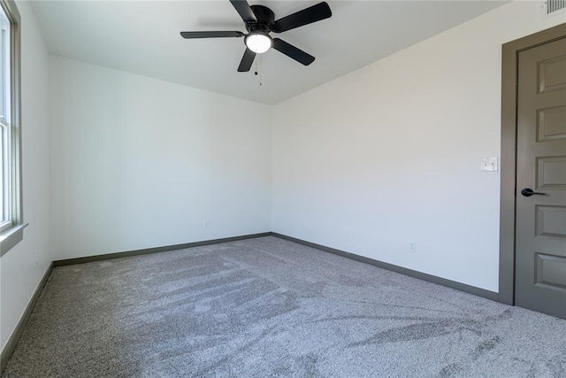 spare room with a ceiling fan, baseboards, and carpet floors