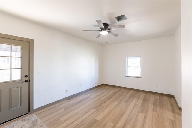 spare room featuring light wood-style flooring, baseboards, and ceiling fan