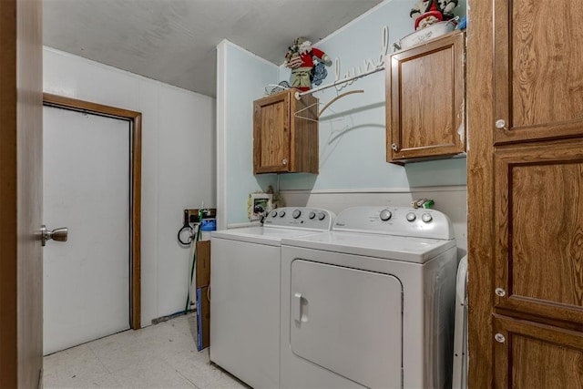 laundry room with cabinet space, independent washer and dryer, and light floors