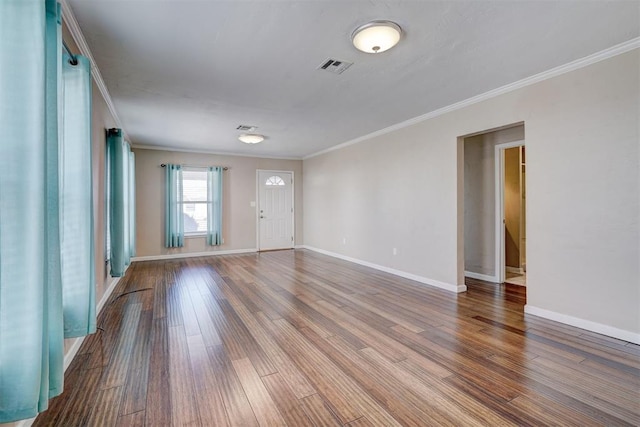 unfurnished room with crown molding, wood finished floors, and visible vents