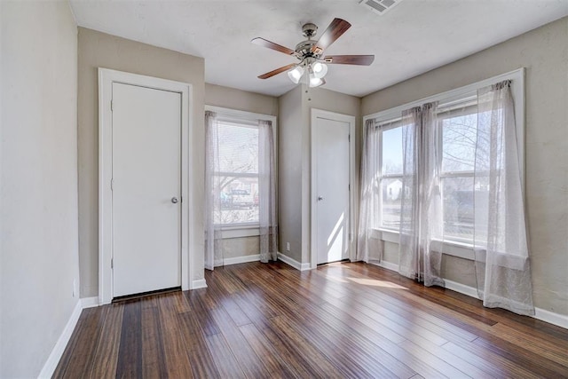 interior space with visible vents, plenty of natural light, wood finished floors, and baseboards