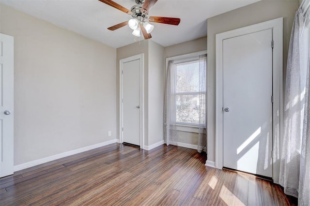 unfurnished bedroom featuring a ceiling fan, baseboards, and wood finished floors